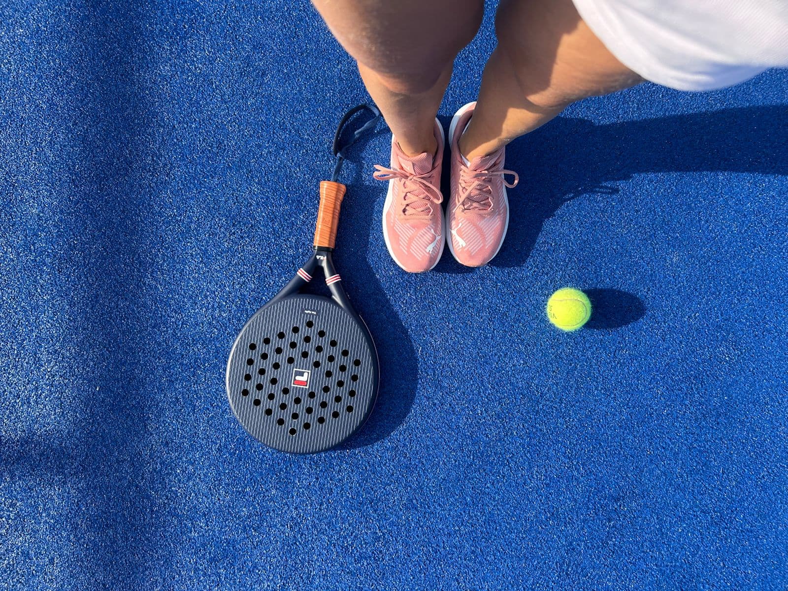 Overhead view of padel gear on a blue court